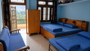 Ein Zimmer mit einem Bett, einem Schlafsofa, einem Kleiderschrank und einem Balkon mit Blick.