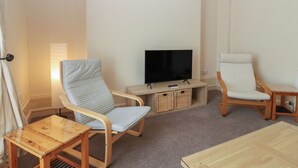 A living room with a television, two chairs, a small table, and a sofa. - Pincerna Apartment Suite 1a (Aberdeen)