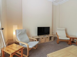 A living room with a television, two chairs, a small table, and a sofa. - Pincerna Apartment Suite 1a (Aberdeen)
