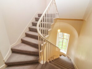 Eine Wendeltreppe mit Teppichstufen und weißen Geländern.