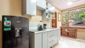 Cafetera o tetera, frigorífico, microondas y placa de cocina