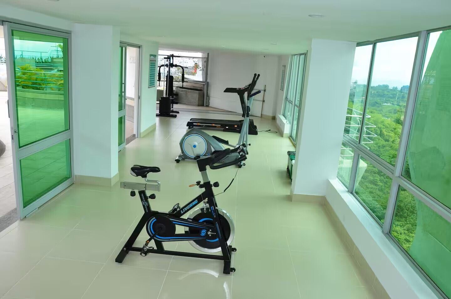 A gym with exercise bikes, a treadmill, and a rowing machine.