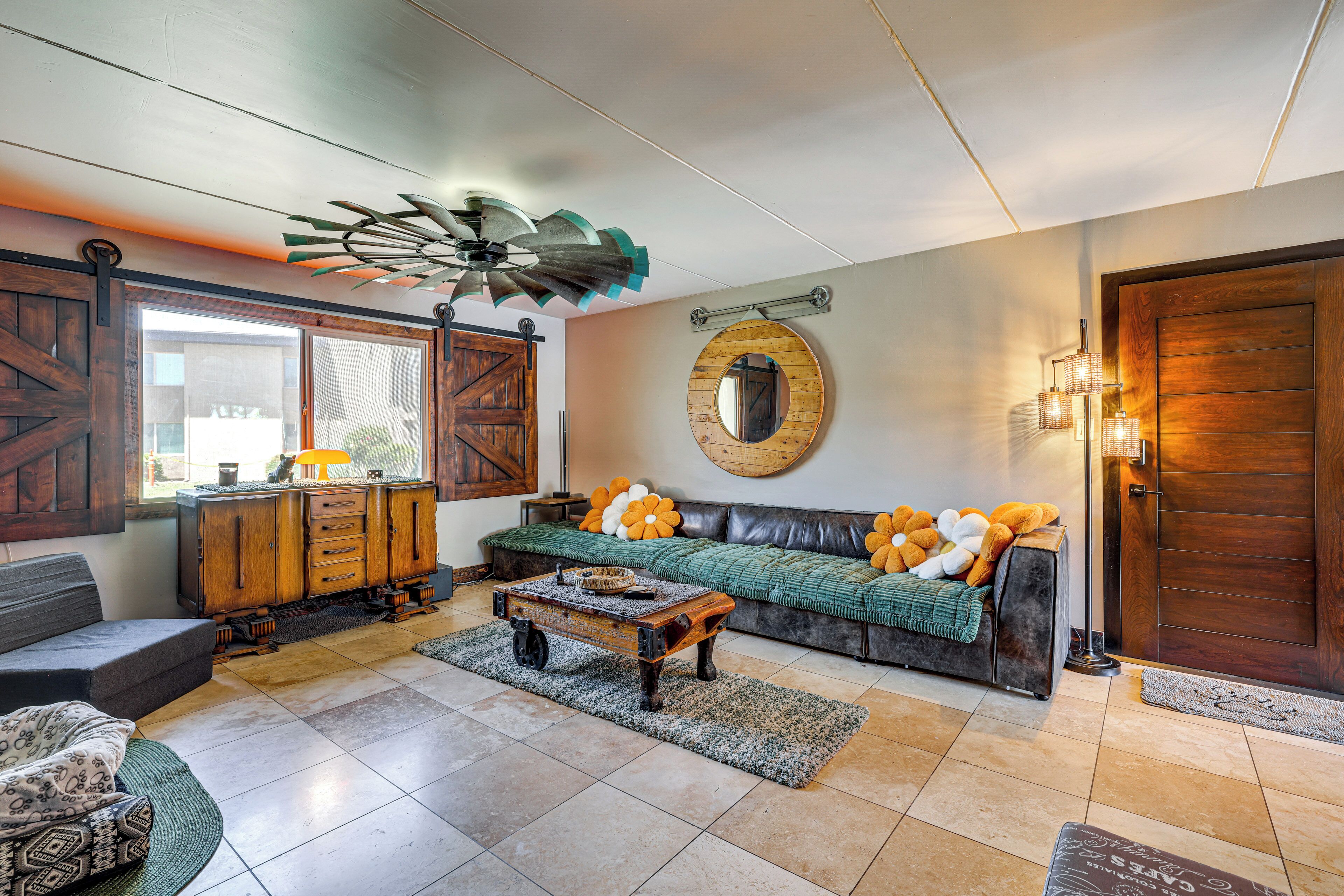 A living room with a sofa, coffee table, and a ceiling fan.