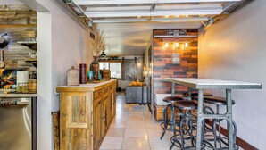 A kitchen with wooden cabinetry, a bar area with stools, and a dining table. - Private Hot Tub + Patio: Condo By Camelback Mtn! (Phoenix)