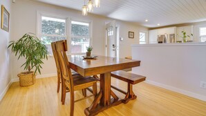 A dining area with a wooden table, chairs, and hanging pendant lights.