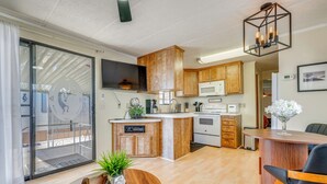 Une cuisine moderne avec des meubles en bois, un îlot central et un coin repas comprenant une table ronde et des chaises.