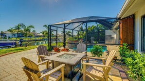 A patio with outdoor furniture, a glass enclosure, and a pool. - Waterfront Pgi, Heated Pool, Dock, 2 King Suites (Punta Gorda)