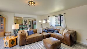 Ein Wohnzimmer mit Ecksofa, Couchtisch aus Holz und einer Lampe.