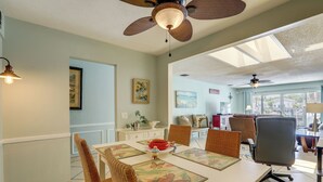 A dining area with a table, chairs, and ceiling fans. - Island Walk to Ocean, Dining w/ Boat Dock & Lift! (Jensen Beach)