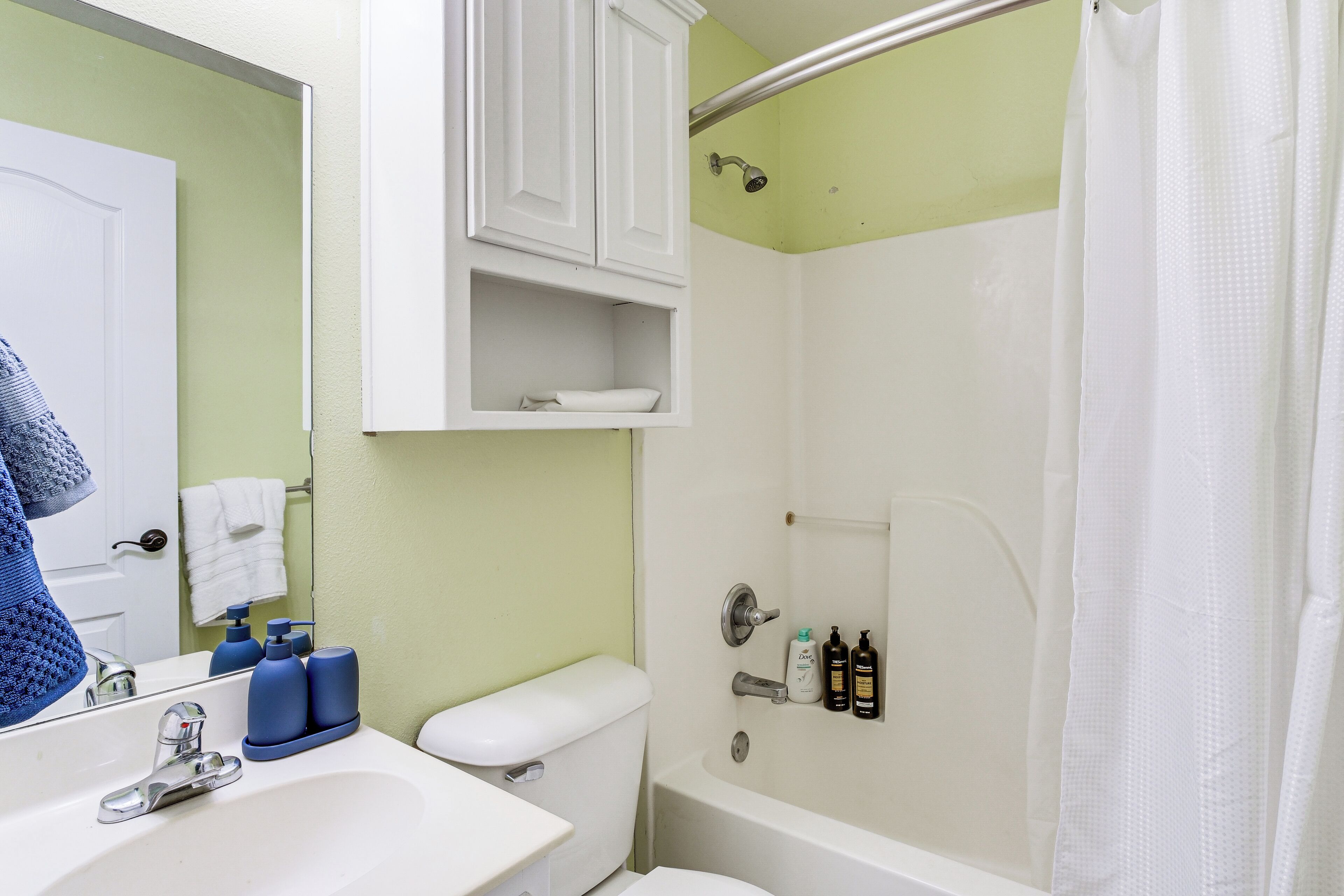 A bathroom with a sink, toilet, and shower.