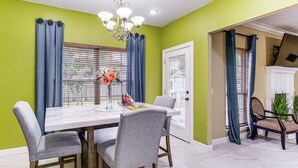 A dining area with a table, chairs, and a chandelier.