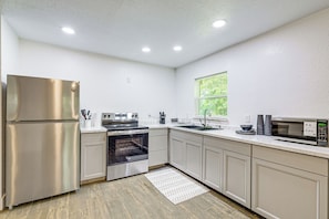 A modern kitchen with stainless steel appliances, a built-in oven, and a window providing natural light. - 6 Mi to Rainbow Springs: Dunnellon Retreat! (Dunnellon)