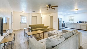 Ein Wohnzimmer mit Sofa, Couchtisch, Fernseher und Deckenventilator.