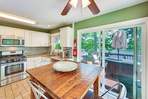 Una cocina con una mesa de madera, electrodomésticos de acero inoxidable y vistas al exterior.