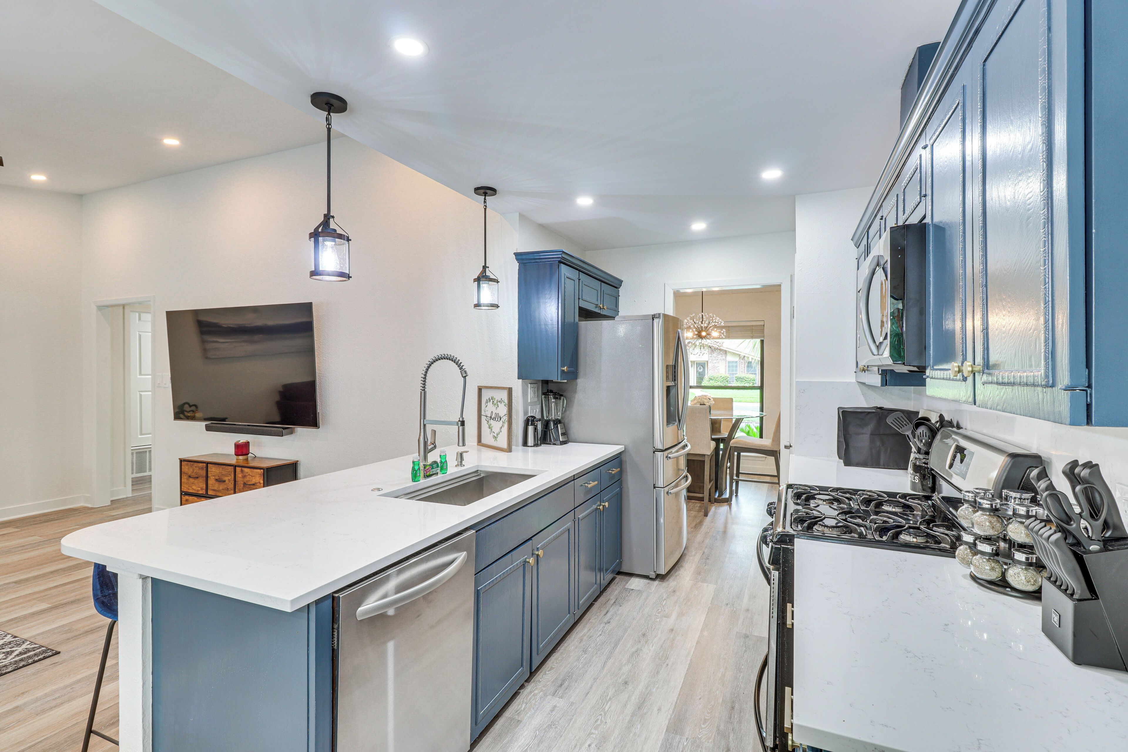 A modern kitchen with a central island, built-in appliances, and pendant lighting.