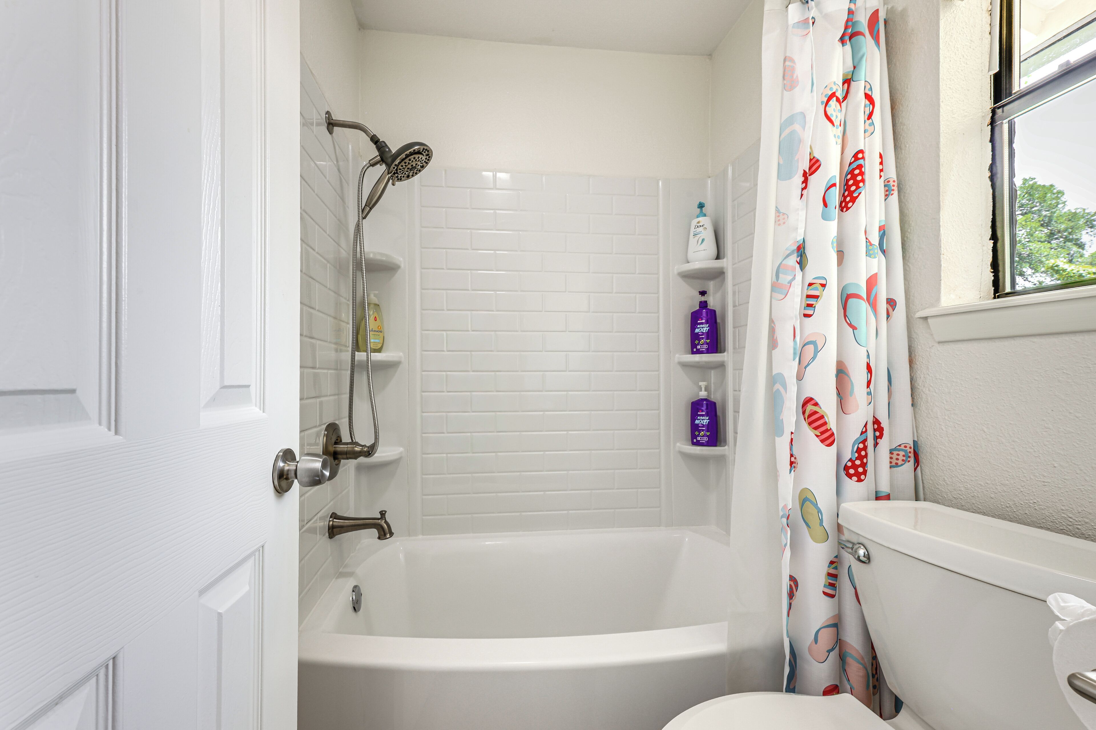 A bathroom with a bathtub, toilet, and shower.