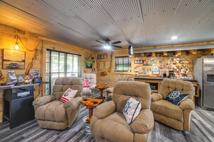 Interior acogedor de una cabaña con sillones cómodos, una zona de bar y un refrigerador.