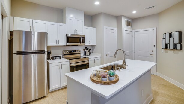 A modern kitchen with white cabinetry, stainless steel appliances, and a central island with decorative items. - 2 Mi to Dtwn Crowley! Modern Escape w/ Pool Access (Crowley)