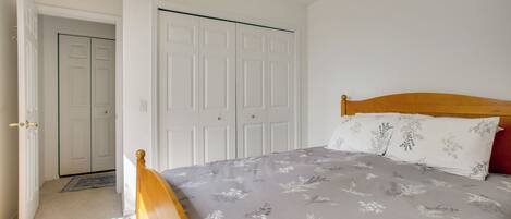 Un dormitorio con cama, armario y puerta que da a otra habitación.