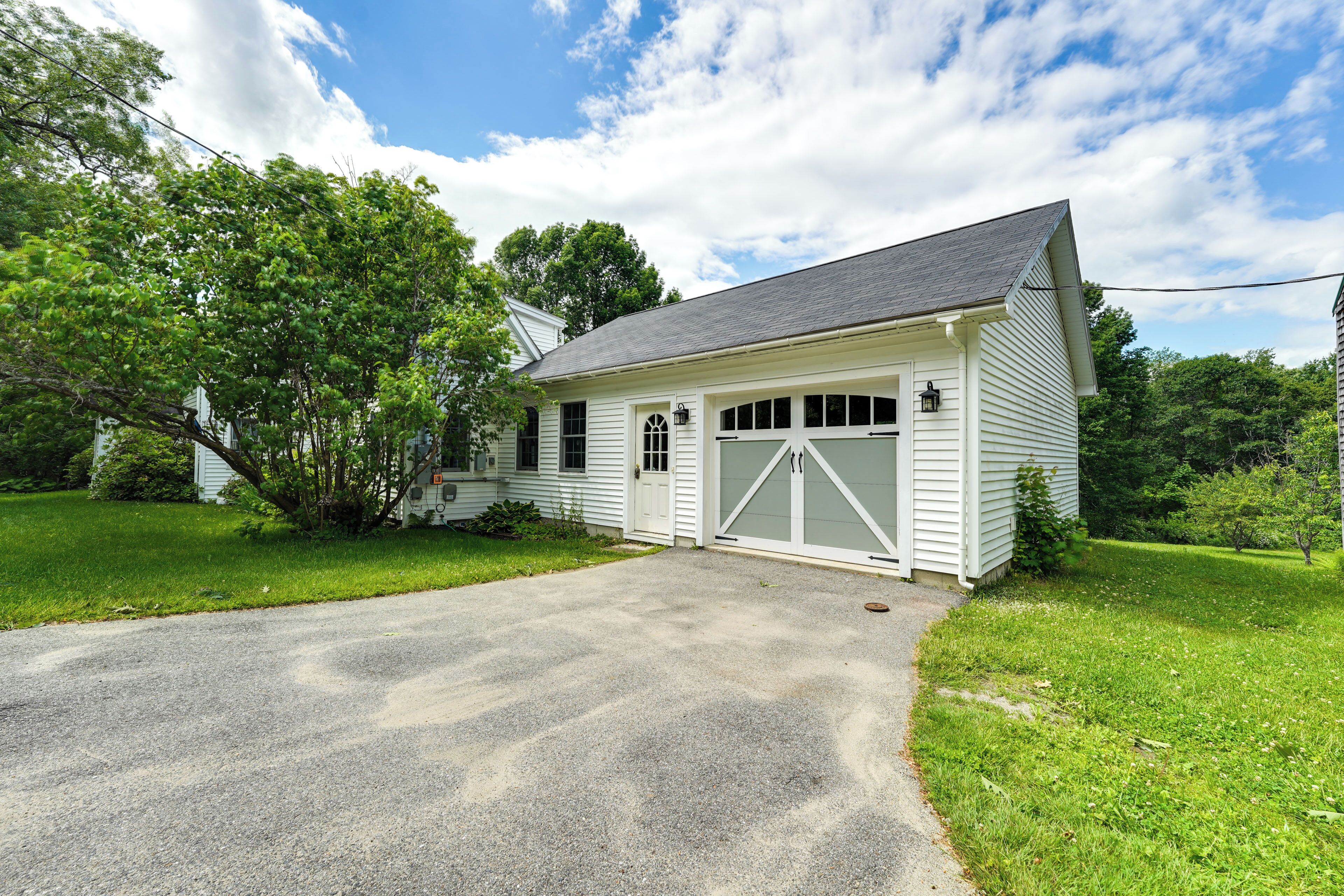 Ein eingeschossiges Haus mit Garage, Auffahrt und Rasenfläche.