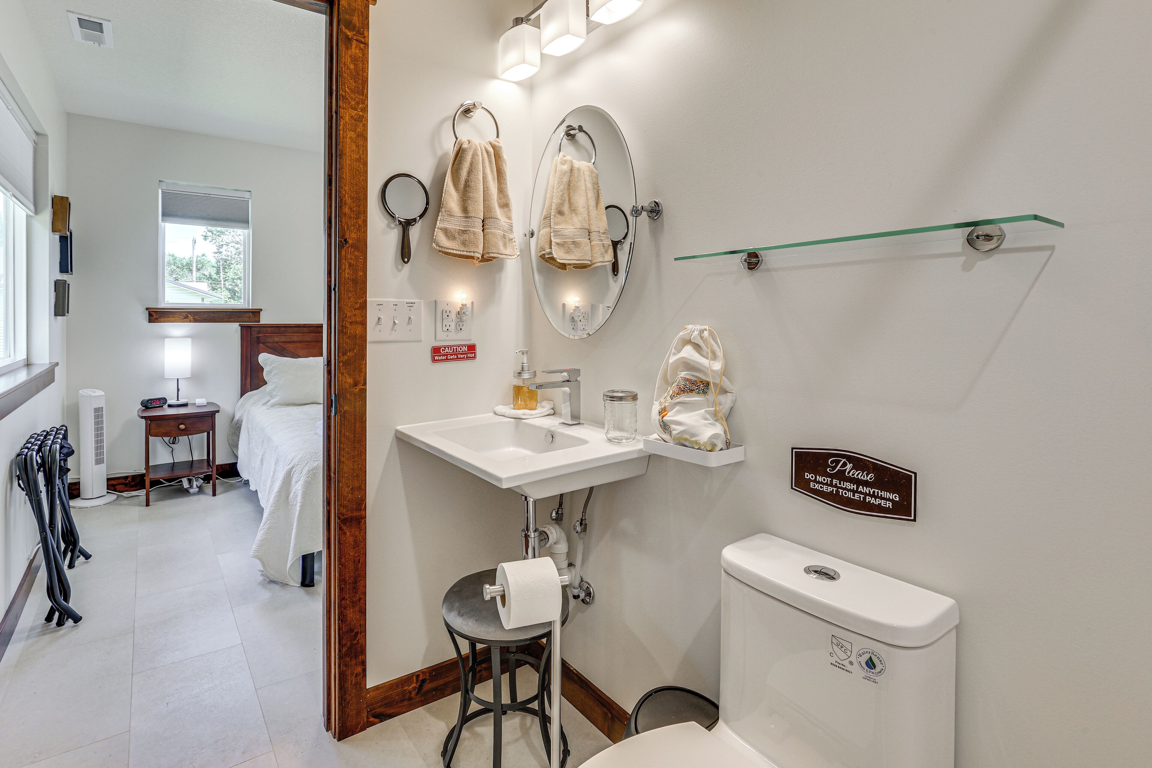 A bathroom with a sink, mirror, towel rack, and toilet.