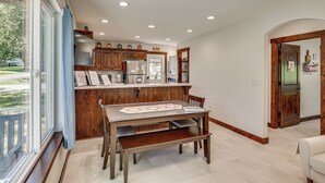 Una cocina con armarios de madera, una mesa de comedor y un banco.