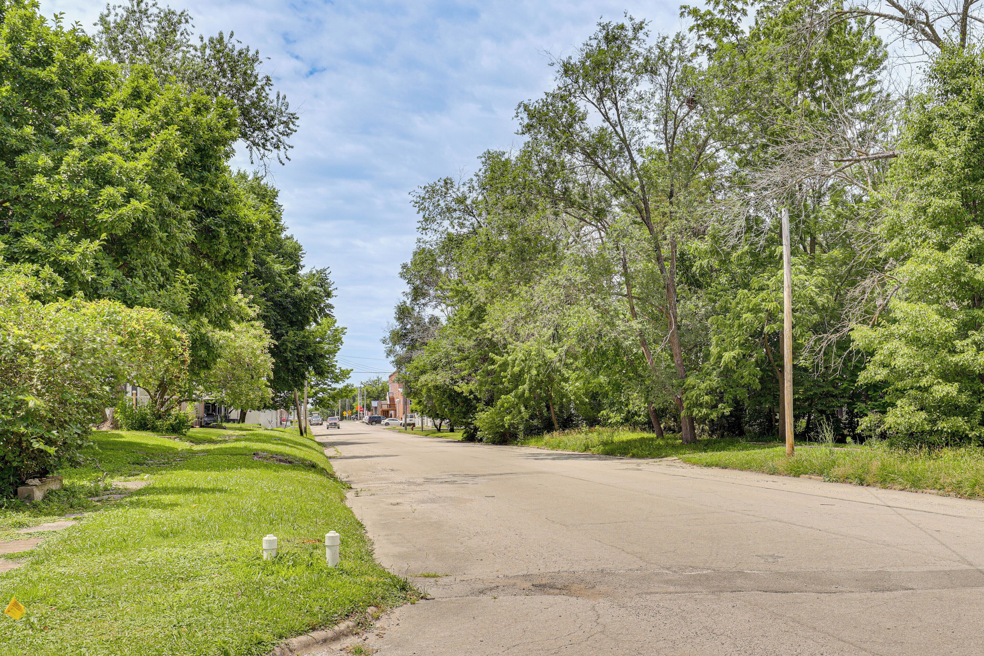 Une rue résidentielle paisible, bordée d’arbres et de maisons.