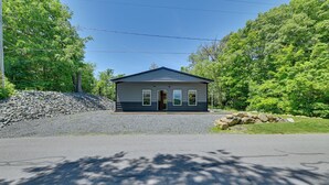 A small, single-story building with a gabled roof, a front door, and a small porch area.