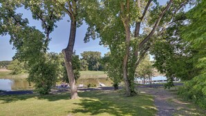 A park with trees, a gravel path, and a body of water.