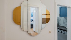 A room with a mirror, a door leading to another room, and a kitchen area with a marble backsplash. - Grand Living Apartment 150 m² 10 Guests 2 Bathrooms Ku'damm (Berlin)