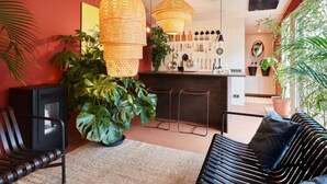 Een moderne keuken met hangende rieten hanglampen, een barruimte met diverse keukengerei, en een grote potplant.