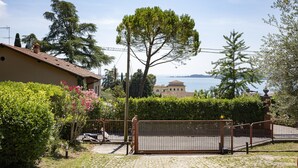 Une propriété située sur la côte, dotée d’une entrée sécurisée par un portail, d’une allée pavée et offrant une vue sur la mer.