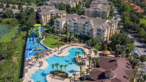 Eine Vogelperspektive zeigt ein Resort mit einem großen Schwimmbecken, einem Wasserpark und mehreren Hotelgebäuden.