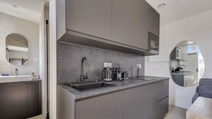 A modern kitchen with a built-in microwave, stainless steel sink, and a coffee maker. - Modern Studio 3P - Aubervilliers (Aubervilliers)
