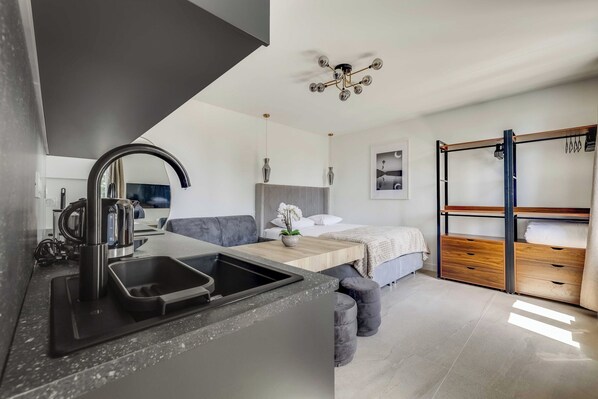 A modern kitchen with a sink, a coffee machine, and a countertop. - Modern Studio 3P - Aubervilliers (Aubervilliers)