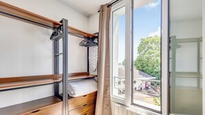 A room with a bunk bed, a wooden dresser, a radiator, and a window with a view of the outside. - Modern Studio 3P - Aubervilliers (Aubervilliers)