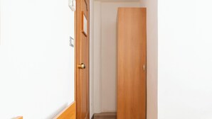 Un pasillo estrecho con una puerta de madera al final.