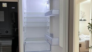 Una cocina moderna con refrigerador, horno y microondas integrados.