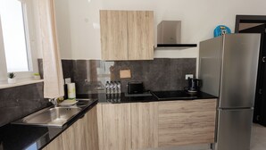 Cuina moderna amb nevera d'acer inoxidable, forn integrat i rentaplat.