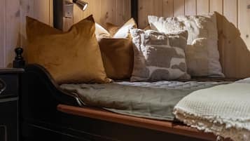 A wooden bed with a headboard, a bedside table, and a lamp.