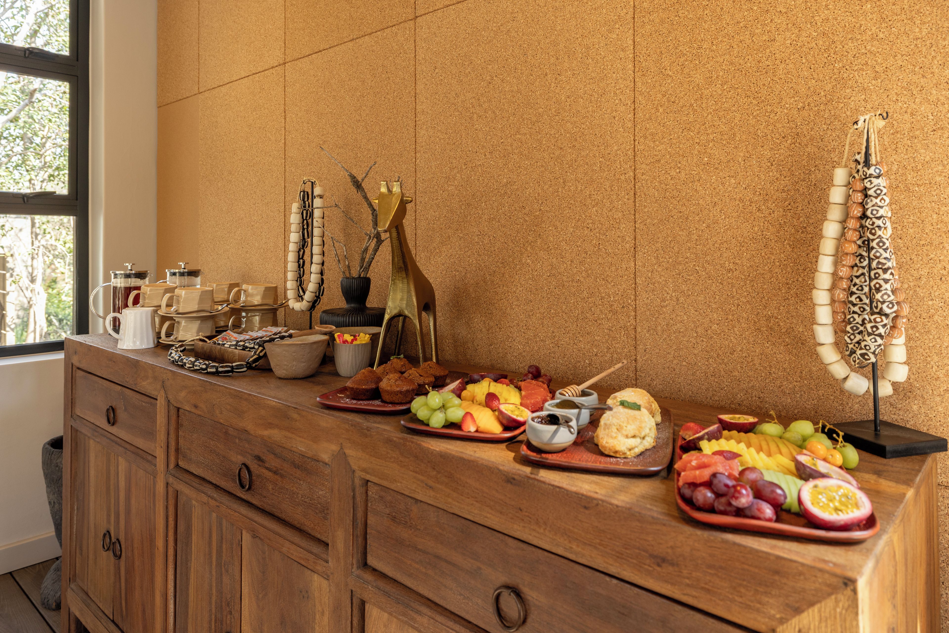 A breakfast buffet with various fruits, pastries, and beverages.