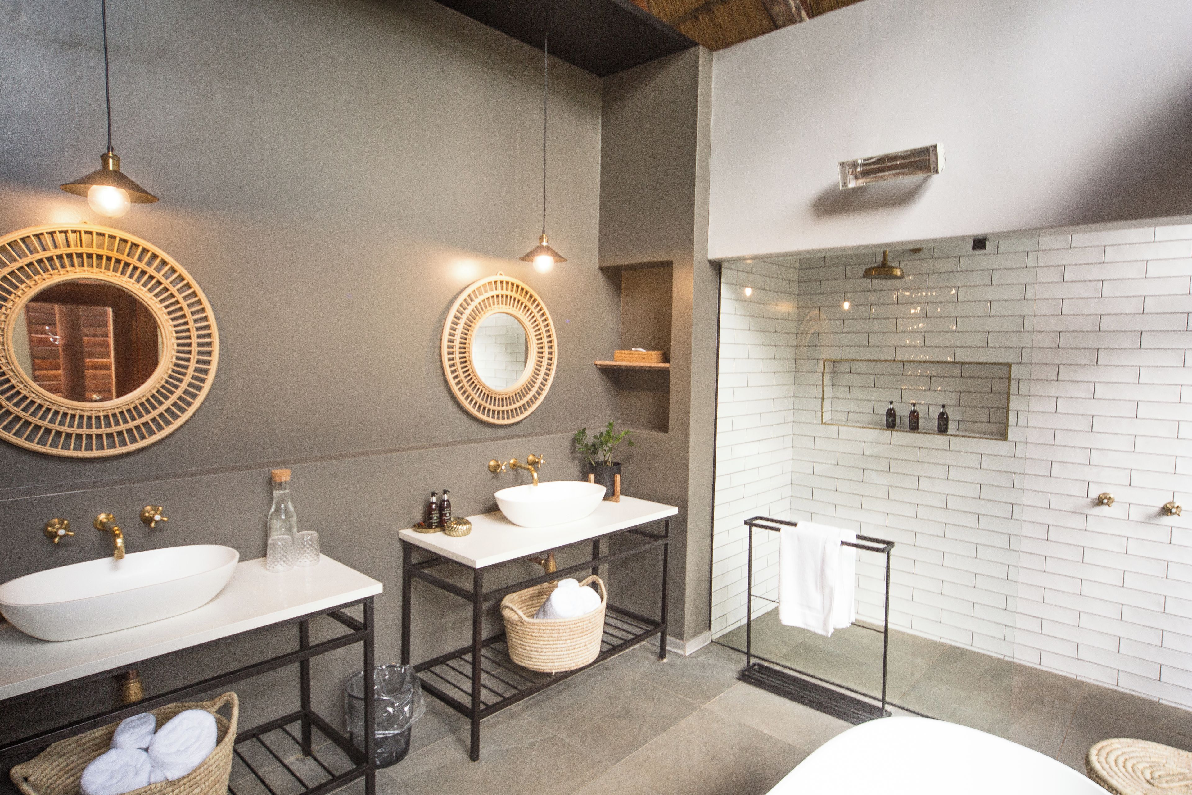 Un baño moderno con dos lavamanos, un espejo, ducha y toallero.