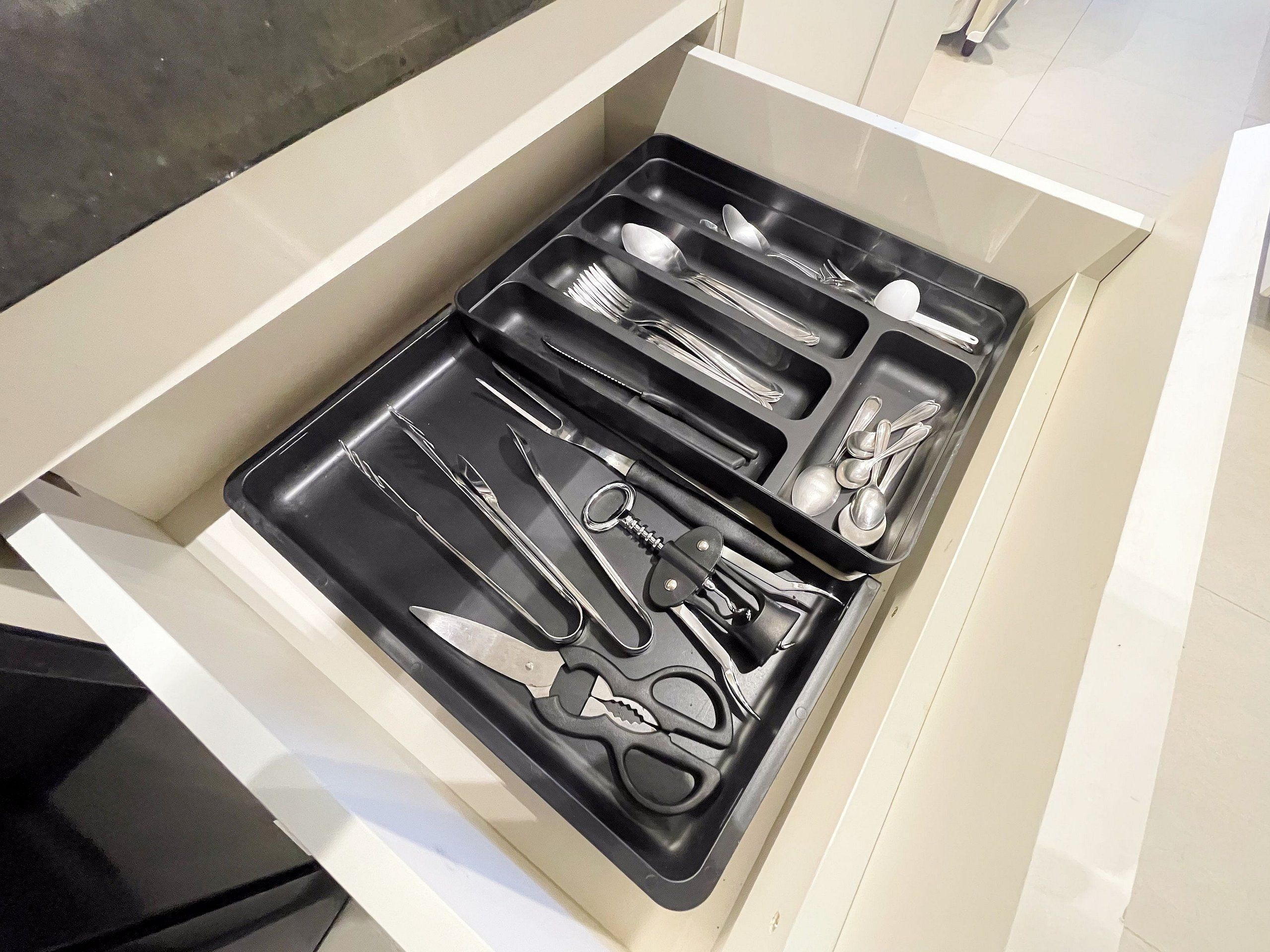 Un tiroir compartimenté contenant divers ustensiles de cuisine.