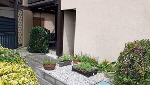 A courtyard with potted plants, a small garden area, and a building entrance. - Charming one-bedroom apartment for a couple, near the beaches of Capbreton, (Capbreton)