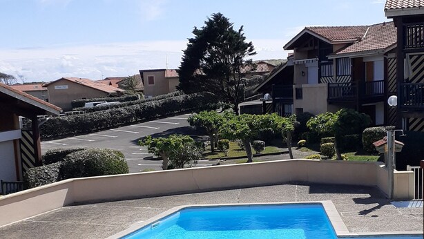 A swimming pool with a clear blue water, surrounded by a low wall and a railing. - Charming one-bedroom apartment for a couple, near the beaches of Capbreton, (Capbreton)