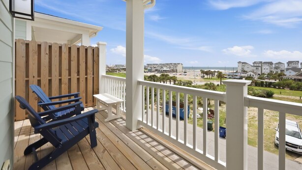 A wooden deck with a white railing, a bench, and a chair. - Circle Pearl-Ocean View Townhome (Atlantic Beach)