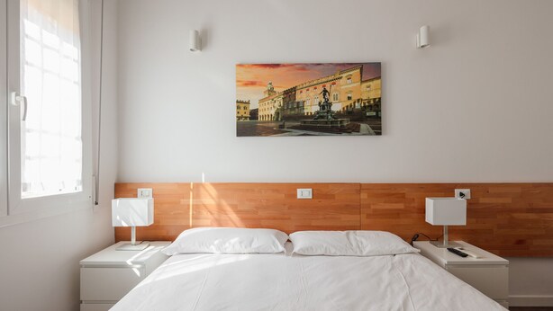 A hotel room with a bed, two bedside tables, a wall-mounted painting, and a window. - Manzoni Room by Wonderful Italy (Bologna)