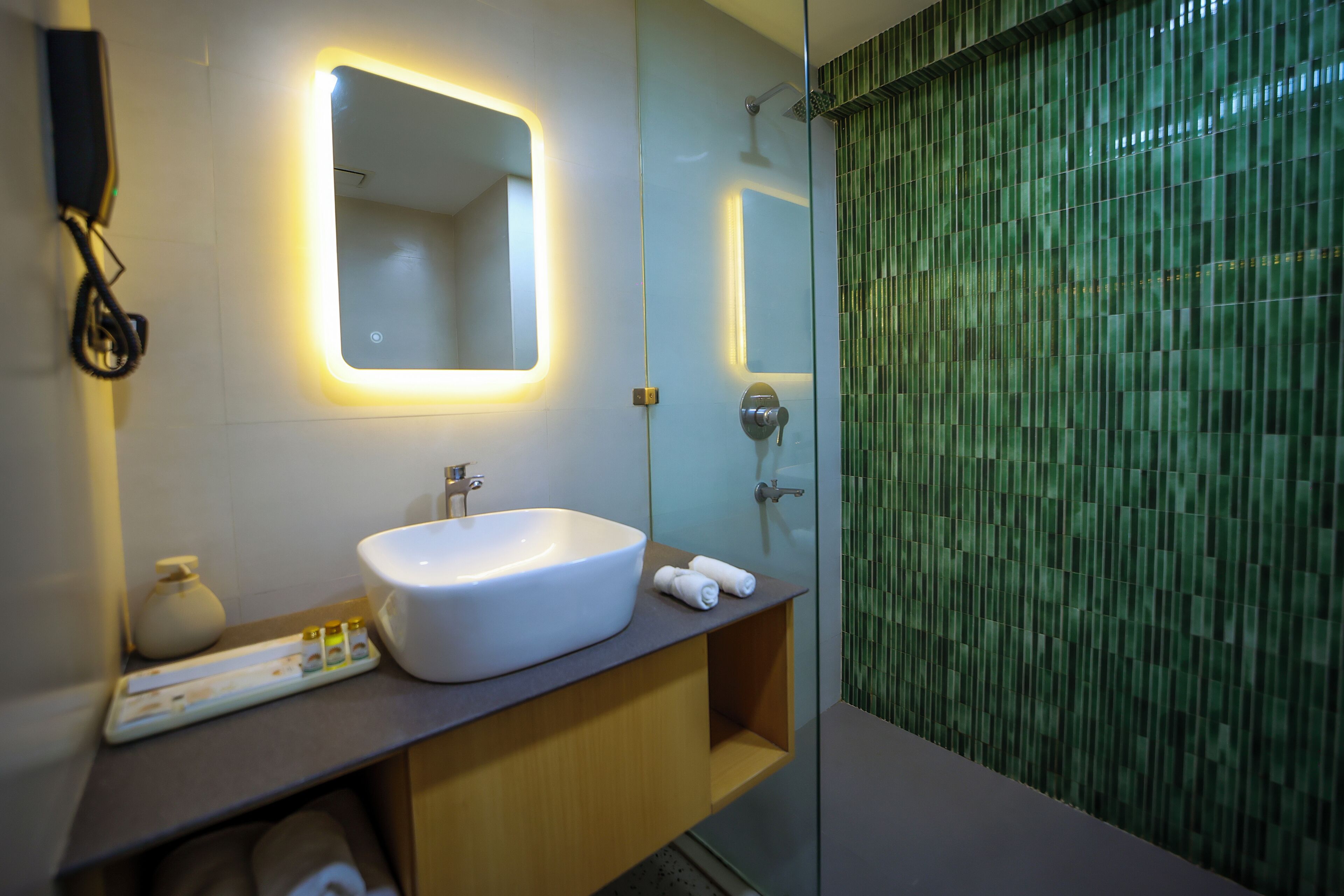 Un baño moderno con un espejo grande, un lavabo blanco y una zona de ducha.