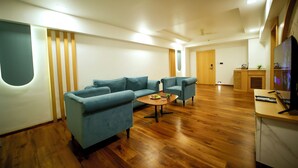 A modern living room with a sectional sofa, a coffee table, and a TV on a wooden stand.