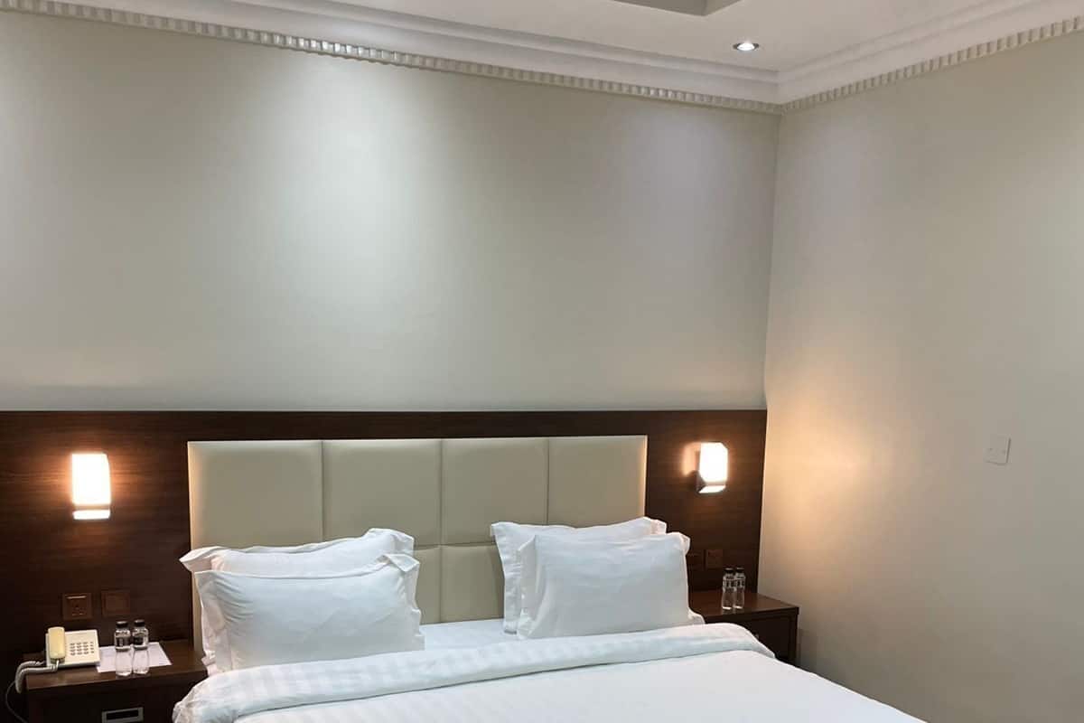 Ein Hotelzimmer mit einem großen Bett, zwei Nachttischen und einer dekorativen Decke.